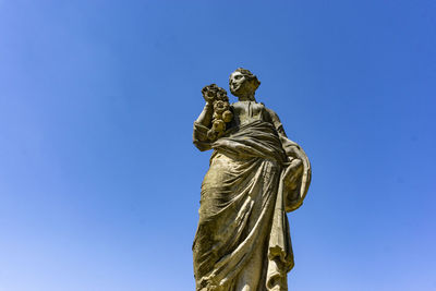 Low angle view of statue against blue sky