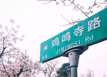 Low angle view of information sign against sky