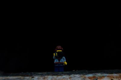 Rear view of boy standing in the dark