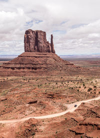 Rock formations on landscape against cloudy sky