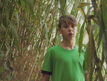 Portrait of boy standing against plants