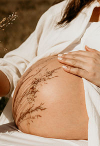 Midsection of woman lying on bed