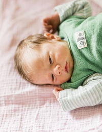 Portrait of cute baby lying on bed