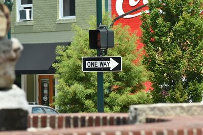 Road sign against trees in city