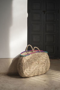 Close-up of wicker basket on table against wall