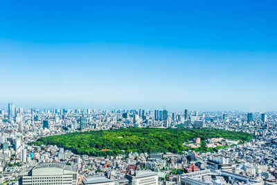 High angle view of city buildings against clear blue sky