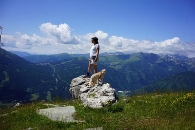 Full length of woman standing on rock against sky