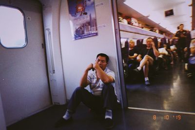 Full length of man sitting in train