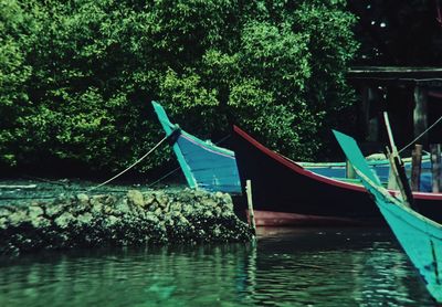 Boat moored in river against trees