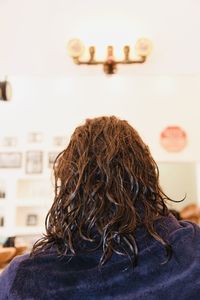 Rear view of woman sitting on ceiling