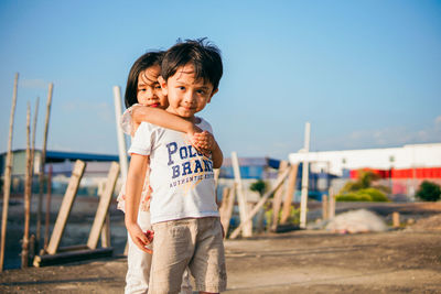 Portrait of boy standing against sky