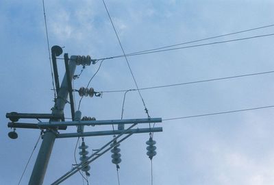 Low angle view of power lines against blue sky