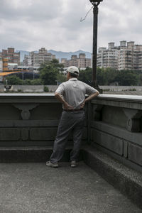 Rear view of man standing against buildings in city