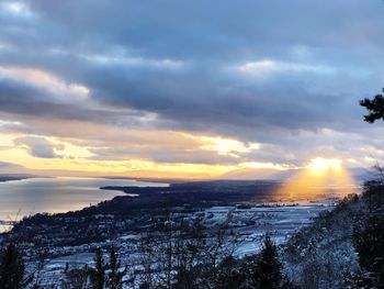 Scenic view of snow covered landscape against sky at sunset