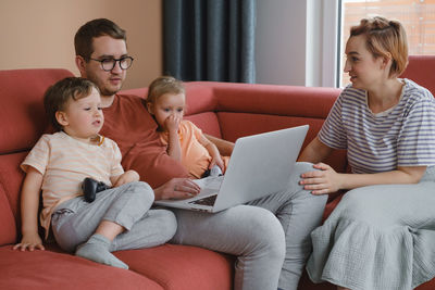 Big happy family watching movies playing games on laptop. mother father kids spending time with