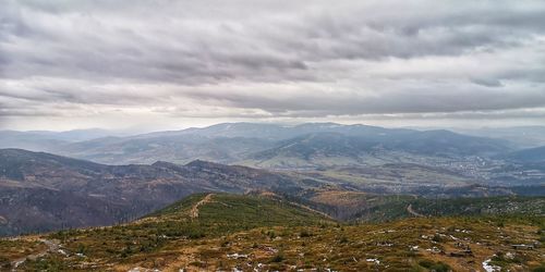 Scenic view of valley and mountains against sky