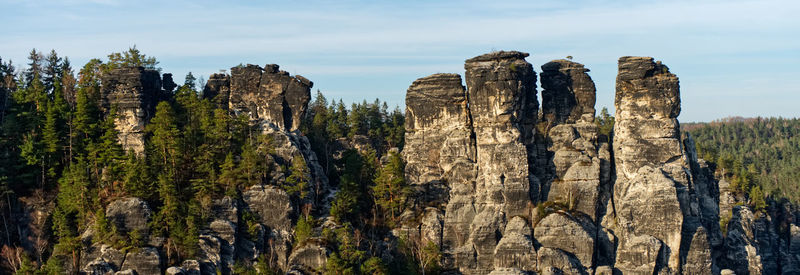 Panoramic view of rocks and trees against sky