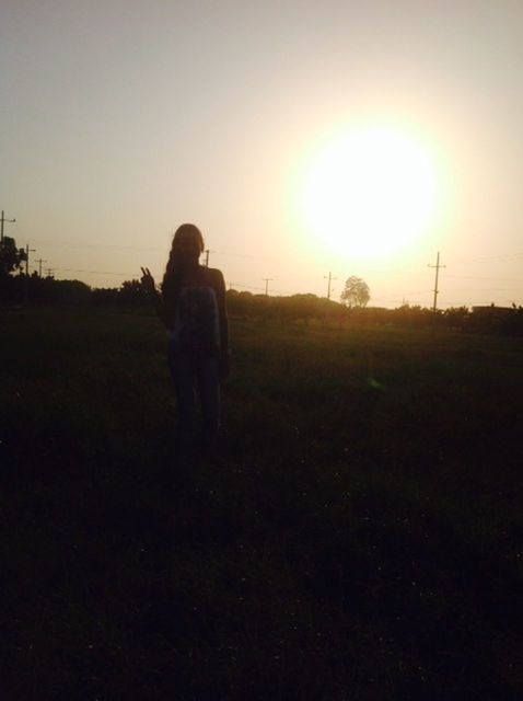 field, lifestyles, grass, leisure activity, sunset, sun, landscape, full length, casual clothing, standing, grassy, sky, sunlight, tranquility, nature, clear sky, tranquil scene, rear view