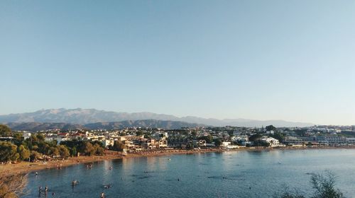 Town by sea against clear sky