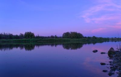 Scenic view of lake against sky at sunset