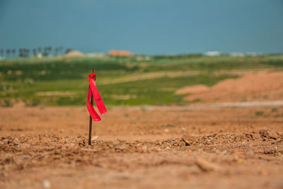 Red flag on field against sky