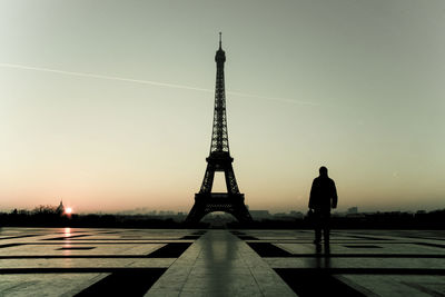 Silhouette man with eiffel tower against sky during sunset