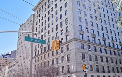 Low angle view of road signal by building