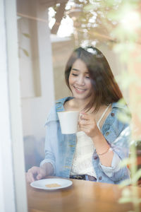 Young woman drinking coffee in cafe