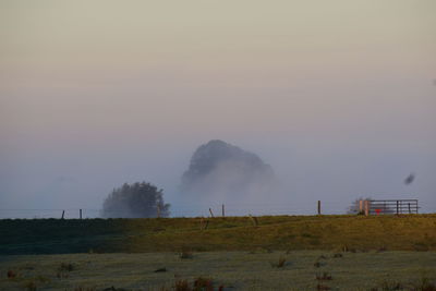 Scenic view of field against sky during foggy weather