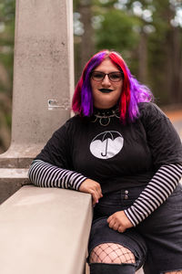 Portrait of young woman sitting on sofa at home