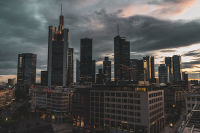 Modern buildings against sky during sunset