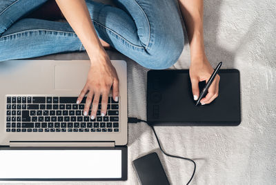 Midsection of woman using mobile phone on table