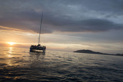 Boats in sea at sunset