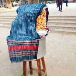 Low section of man holding ice cream on street