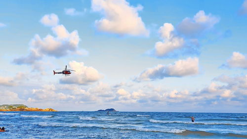 Airplane flying over sea against sky