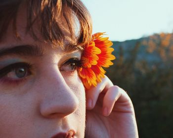 Close-up portrait of woman with red flower