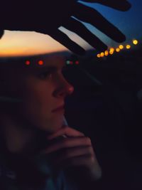 Close-up of woman looking away against black background