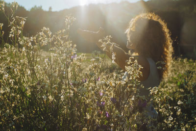 Rear view of woman standing amidst plants