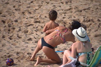 Rear view of friends enjoying at beach