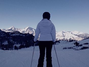 Woman standing on snow covered landscape