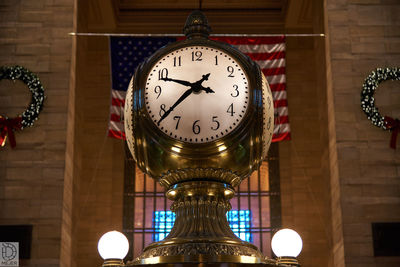 Low angle view of illuminated clock in building