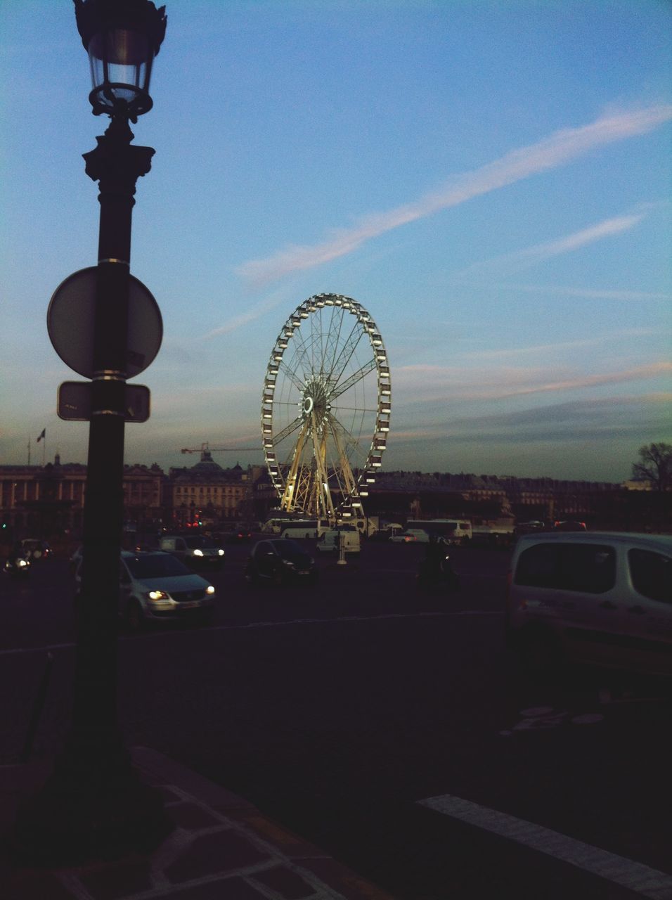 ferris wheel, amusement park ride, amusement park, arts culture and entertainment, built structure, architecture, sky, illuminated, low angle view, city, building exterior, tall - high, travel destinations, circle, tourism, famous place, travel, silhouette, capital cities, dusk