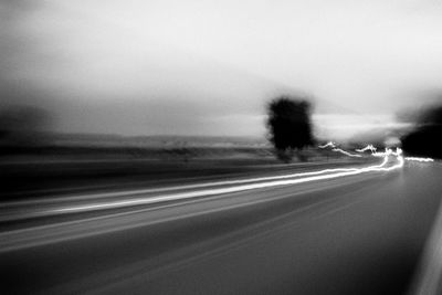 Blurred motion of car on road against clear sky