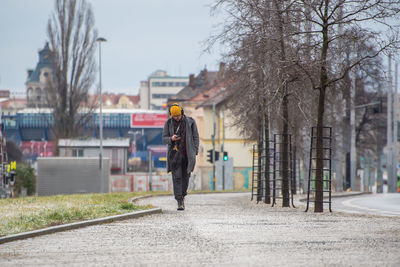 Rear view of man walking on street in city