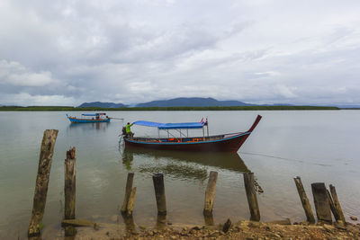 The long-tail boat services tourists visiting in the bay at phang nga, thailand.