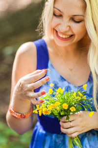 Midsection of woman holding flower bouquet