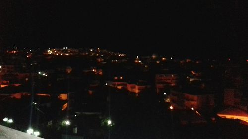 Illuminated cityscape against sky at night