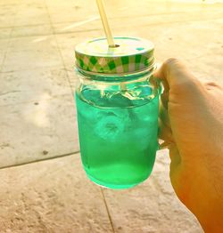 Close-up of hand holding drink in jar