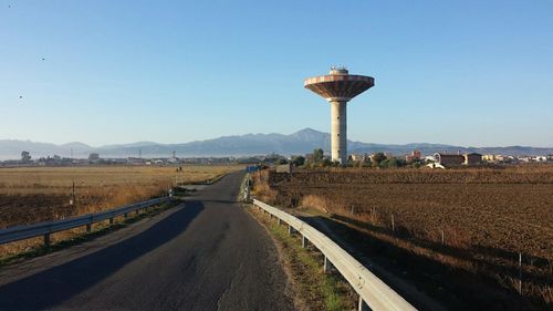 Road amidst landscape against clear blue sky