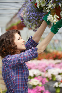 Rear view of woman standing on flowering plant